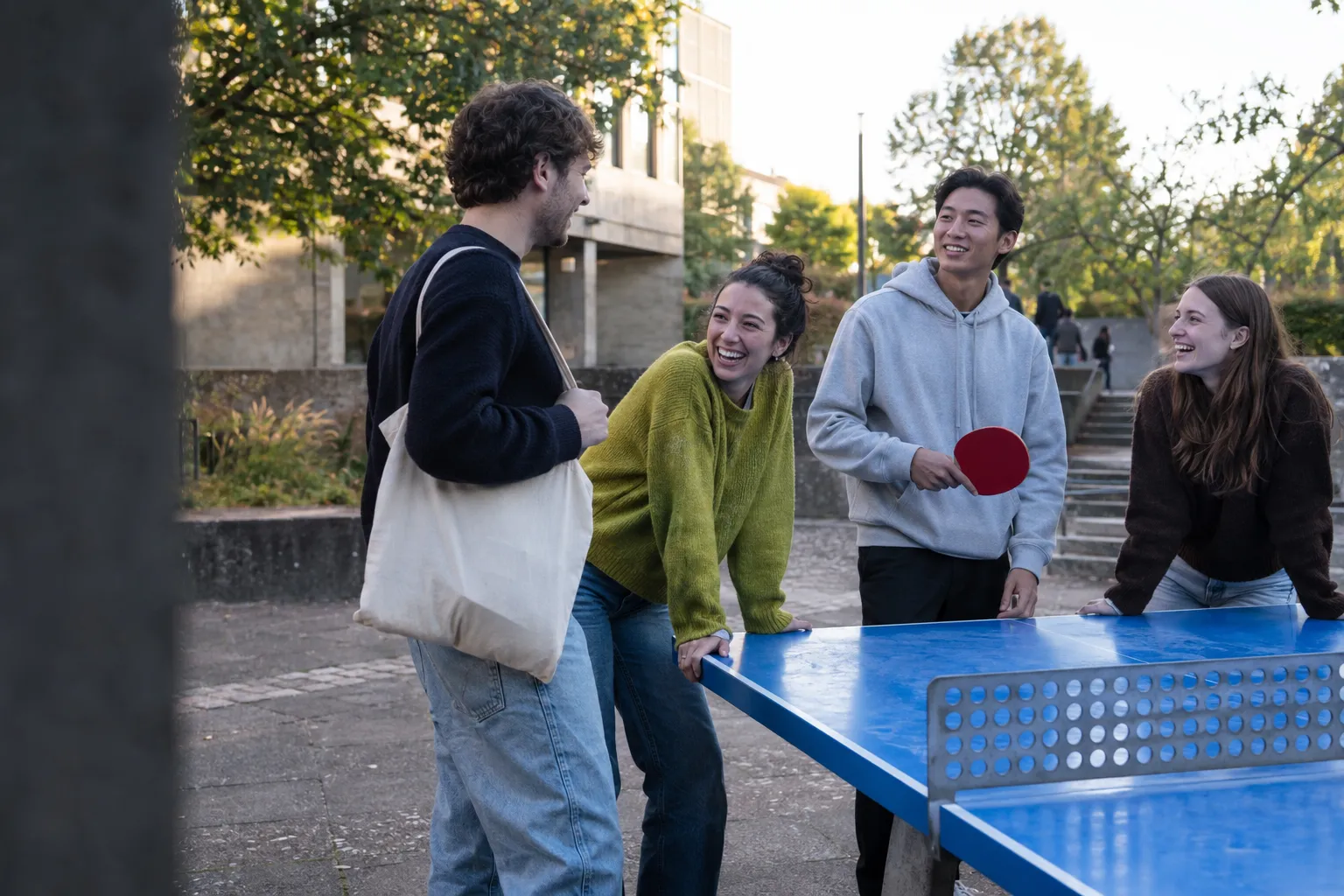 Illustrative Campus-Szene: Freunde unterhalten sich an einer Tischtennisplatte.